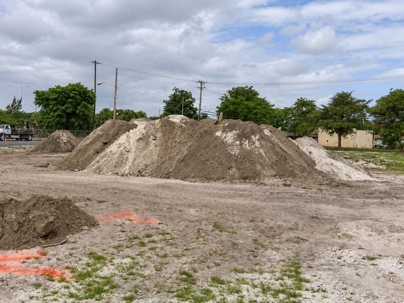 Excavator removing contaminated soil at a former fuel site